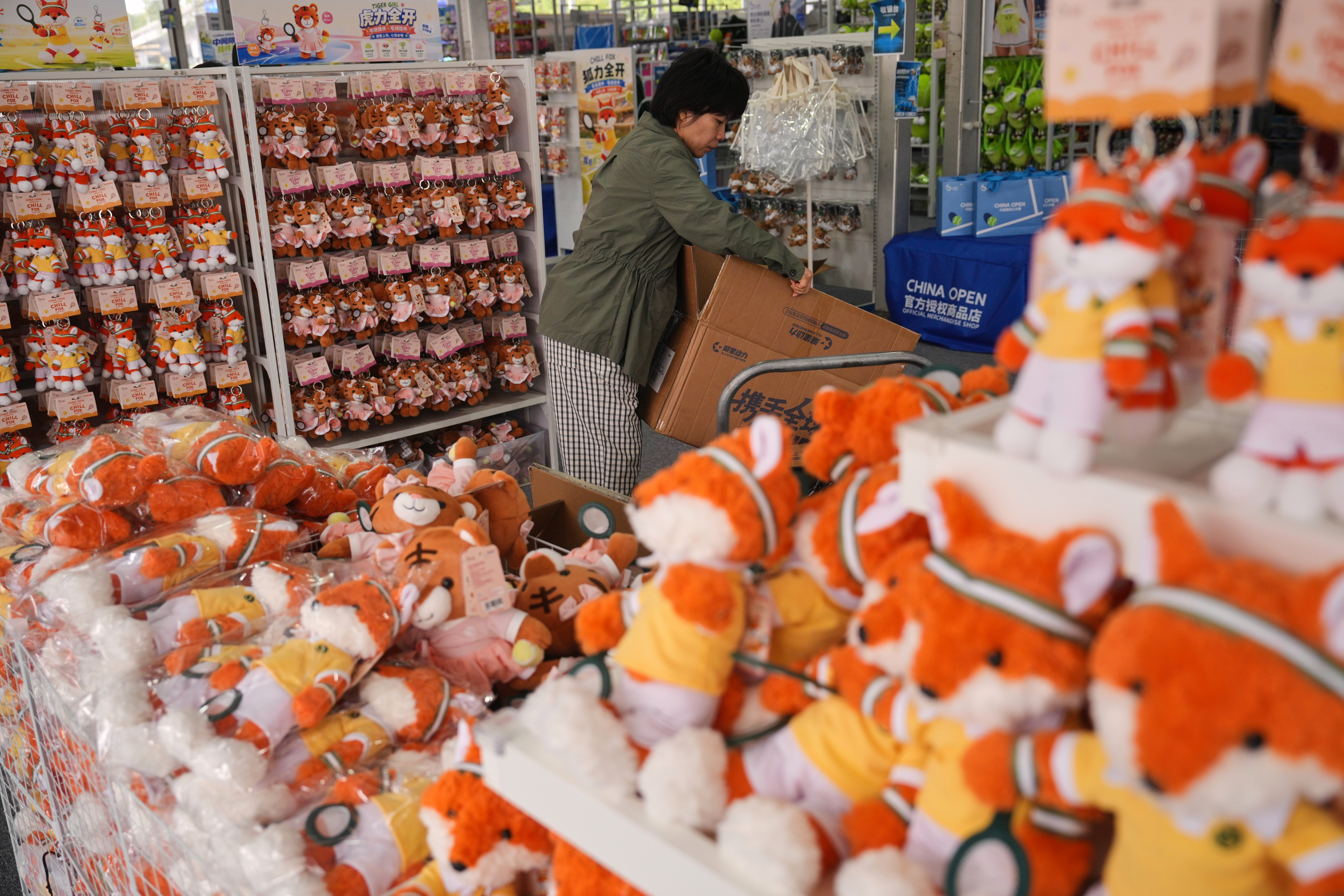 Un trabajador repone juguetes de peluche en una tienda de recuerdos de Pekín, el 30 de septiembre de 2026